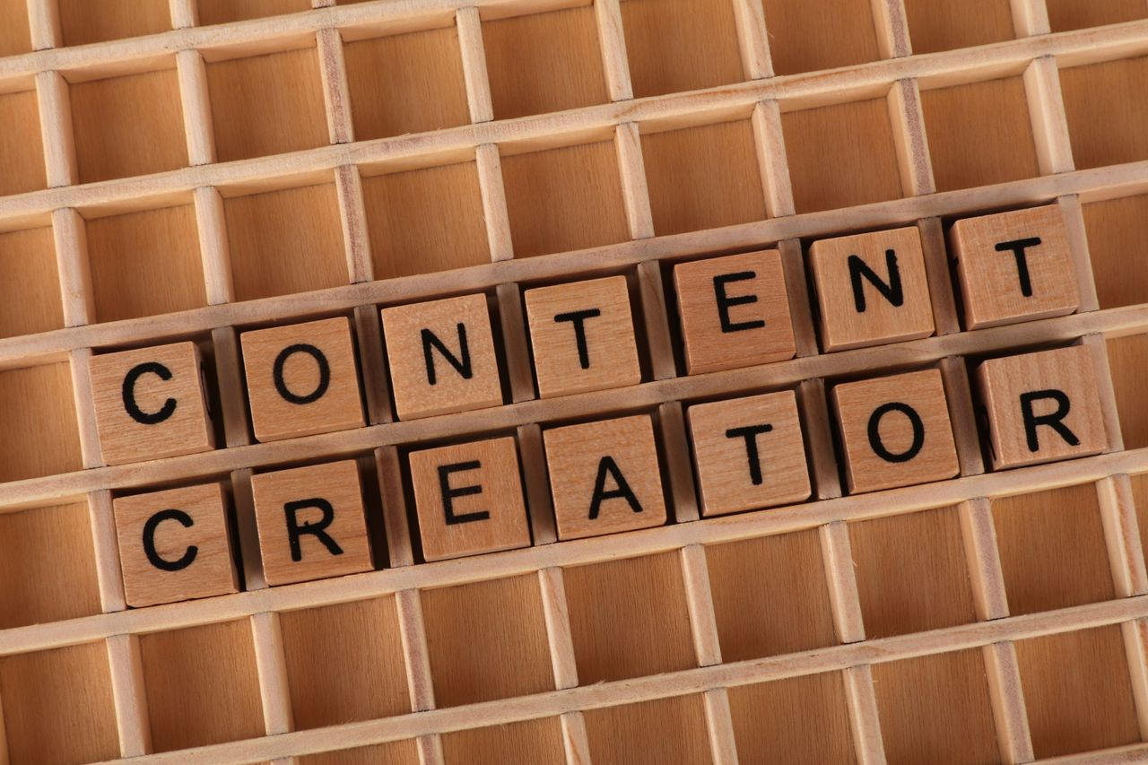 team-02 Wooden letter blocks arranged to spell Content Creator symbolizing creativity and digital media.